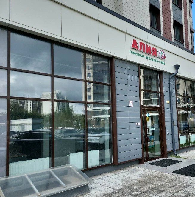 Фасад кафе «Алия» в Казани: витражные окна и красная вывеска «Алия — семейная эколавка-кафе»